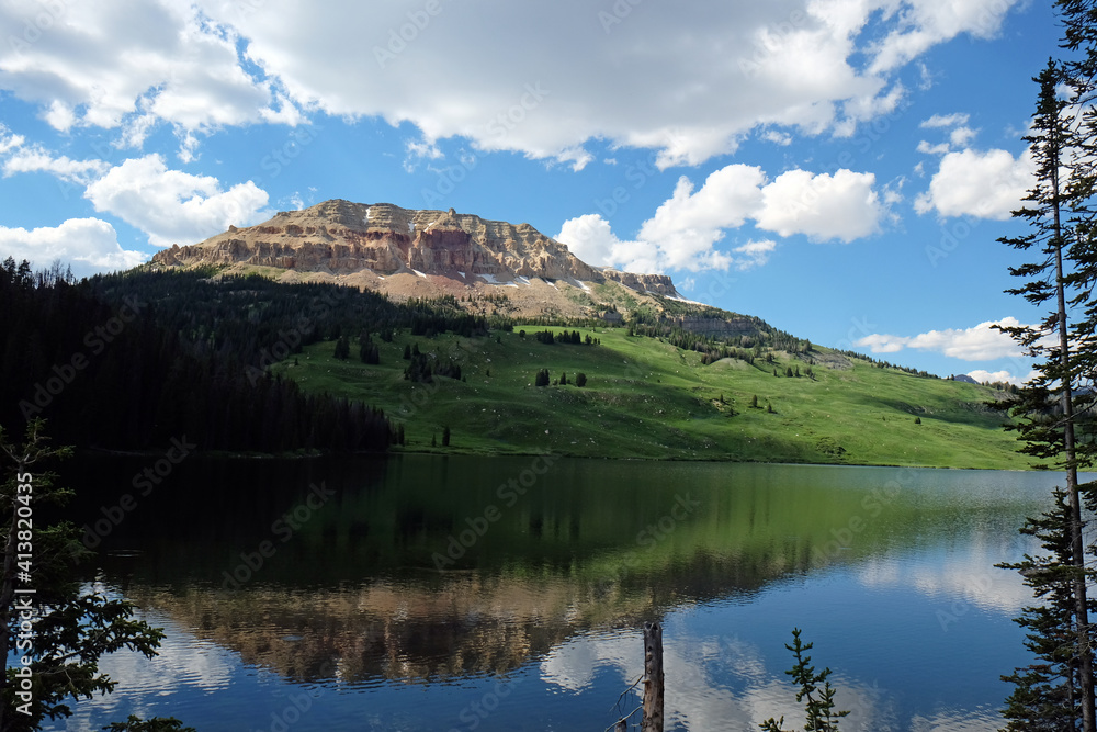 Rocky Mountain Reflected in Lake with Puffy White Clouds and Blue Sky Rocky Mountain Reflected in Lake with Puffy White Clouds and Blue Sky
