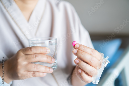 Patient eating medication to treat disease, holding pill tablet and glass of water in hands for taking medicine, Covid-19 virus supplements antibiotic painkiller to relieve pain,revent virus spreading