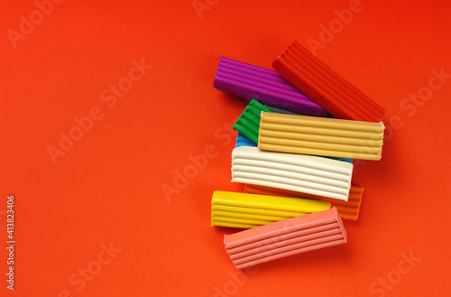 Children's colorful plasticine bricks on a red background. Copy space.