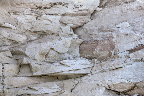 Grungy stone rocky slate facade of worn mining quarry. Uneven strong caving chipped granite slices of shabby boulder edge blocks. Rustic hewn bumpy grunge of vintage big bold cliff for 3D rough design