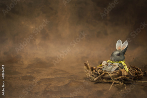Easter bunny in nest on rustic broun background
