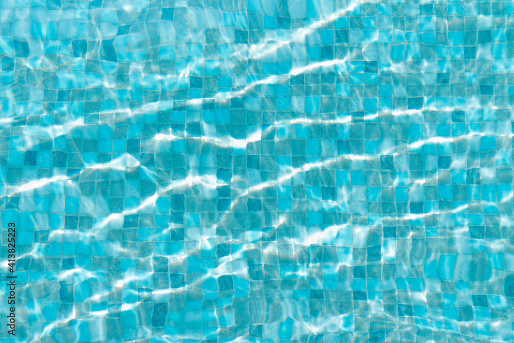 Water surface of swimming pool with sun reflection