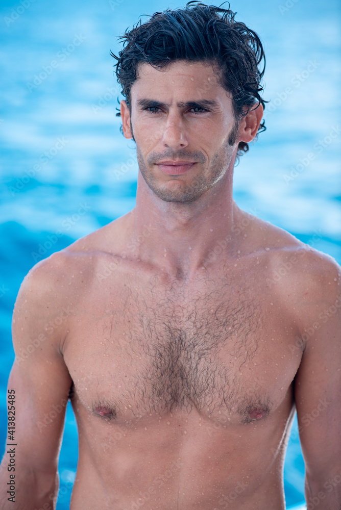 Portrait of handsome man, shirtless surfer with and blue ocean on background in Maldives Portrait of handsome man, shirtless surfer with and blue ocean on background in Maldives