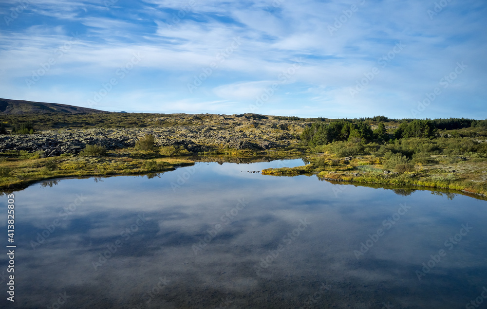 Idyllic landscape of lake with crystal tranquil water against gently sloping hill Idyllic landscape of lake with crystal tranquil water against gently sloping hill