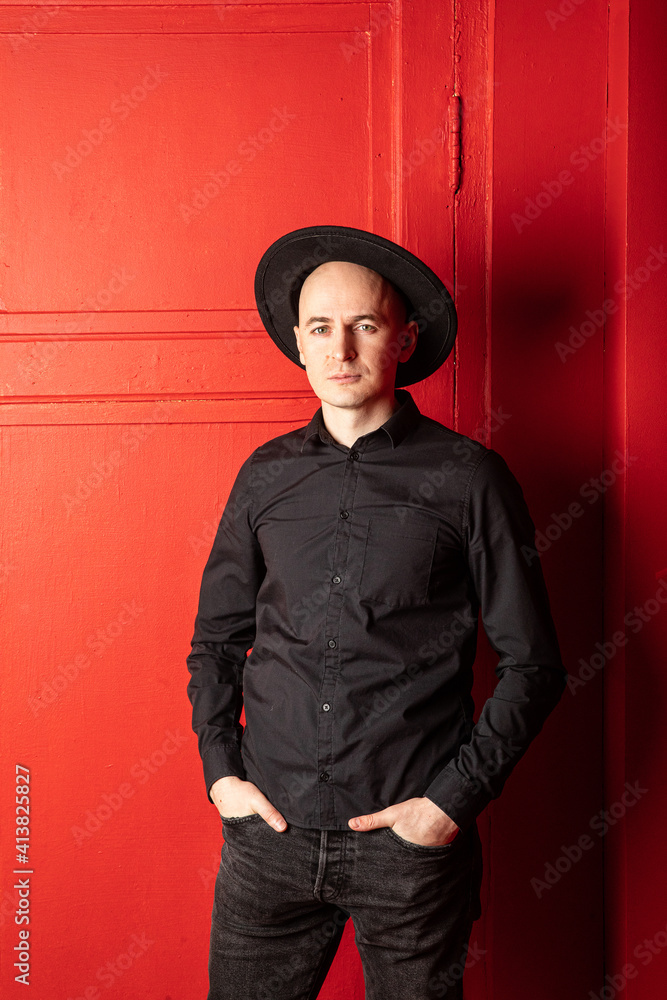 Man in black shirt and hat on red background Man in black shirt and hat on red background