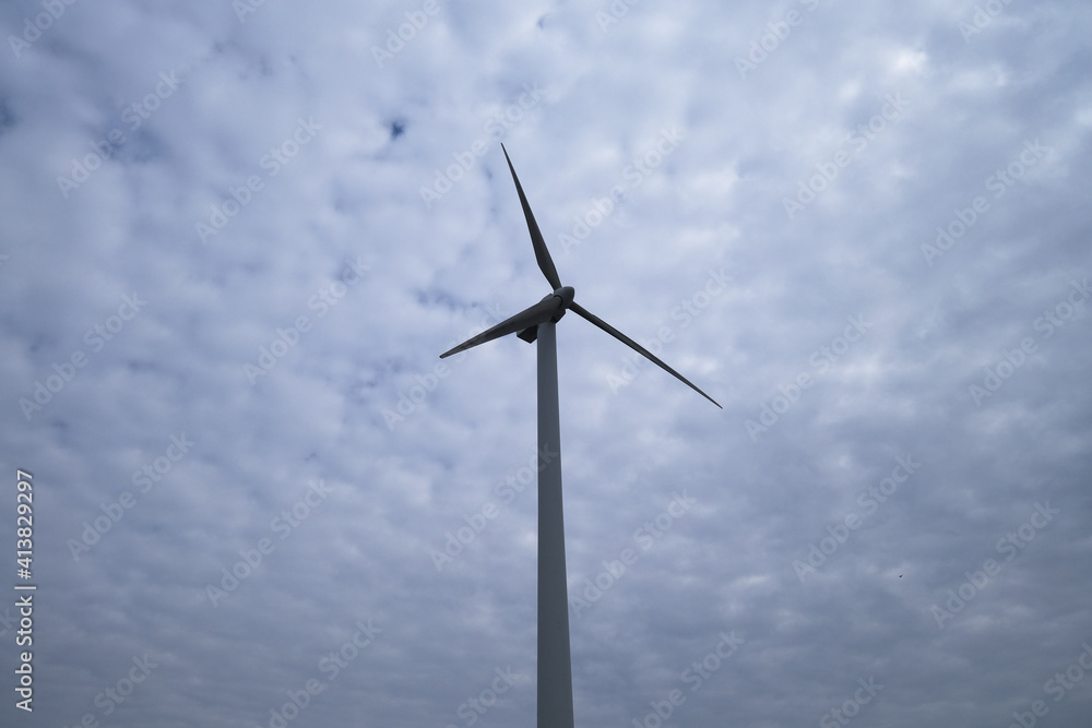 one wind power turbine in the center, white cloud sky background one wind power turbine in the center, white cloud sky background