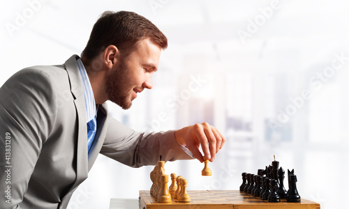 Businessman moving chess figure in chessboard