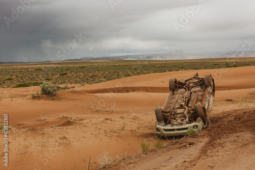 flipped car off of a slippery dirt road in the desert road to the maze photo