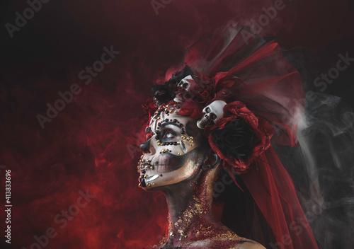 Santa Muerte Young Girl with Artistic Halloween Makeup and with Sculls photo