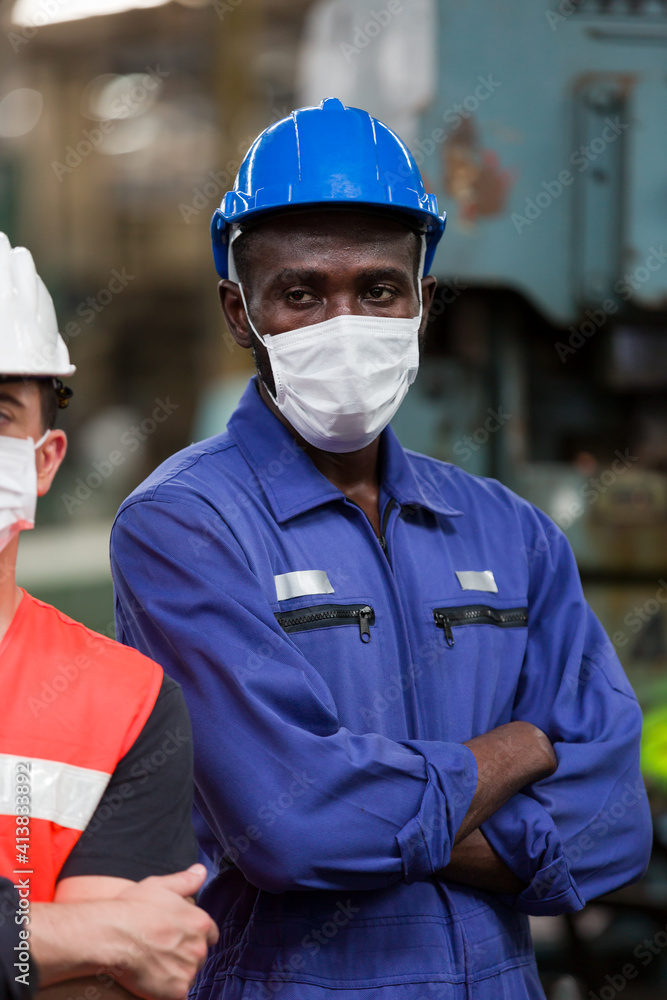Black male engineer wearing protective medical face mask at work in the industry factory. African American male worker wearing protective medical face mask for health in the factory Black male engineer wearing protective medical face mask at work in the industry factory. African American male worker wearing protective medical face mask for health in the factory