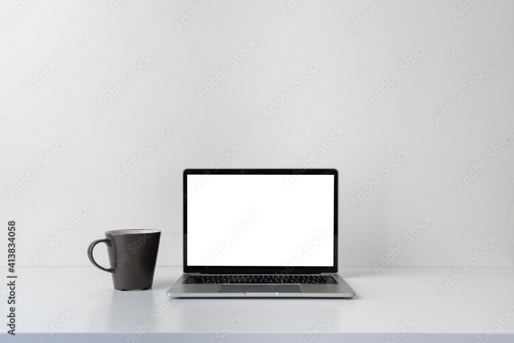 Modern contemporary workspace with blank screen laptop computer and coffee cup on office desk table on white background for copy space. Home office workplace concept. Modern contemporary workspace with blank screen laptop computer and coffee cup on office desk table on white background for copy space. Home office workplace concept.