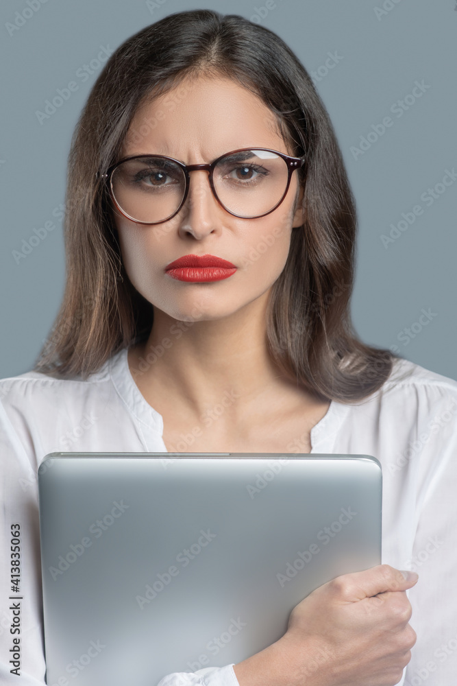 Serious young woman with stern look in glasses