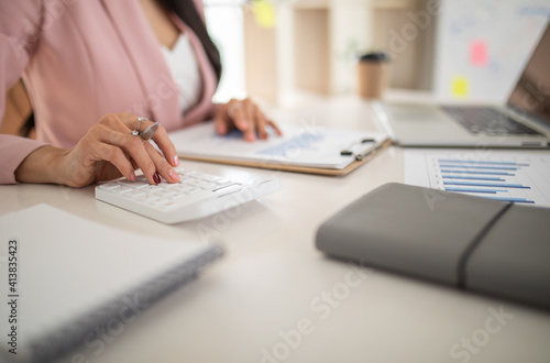 Business accounting Financial concept, Woman using calculator with computer laptop, 