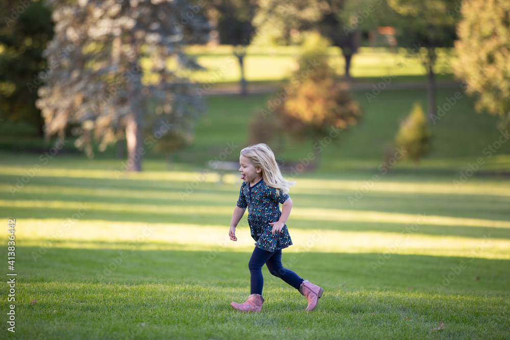 blonde girl running outside through field sticking tongue out blonde girl running outside through field sticking tongue out