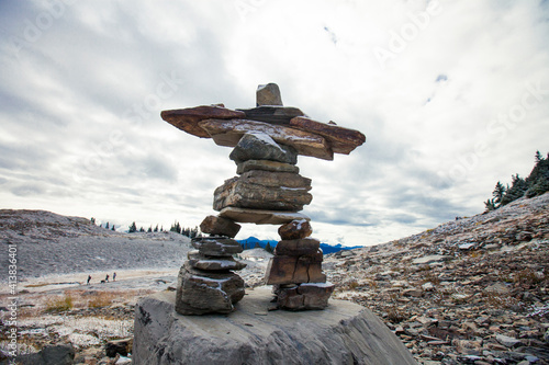 Inukshuk standing tall in a mountain setting. photo