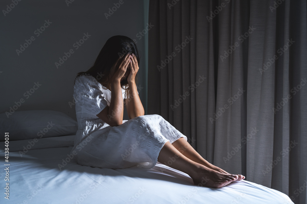 Lonely young woman feeling depressed and stressed sitting in the dark bedroom, Negative emotion and mental health concept Lonely young woman feeling depressed and stressed sitting in the dark bedroom, Negative emotion and mental health concept