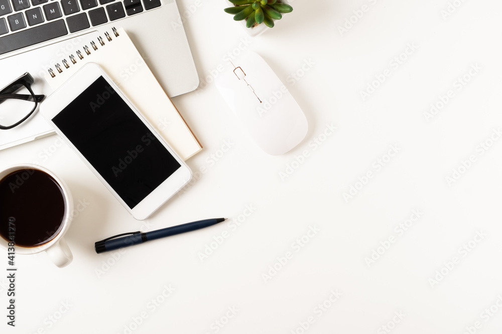 White office desk table with laptop, and smartphone and pen with coffee cup, copy space, top view