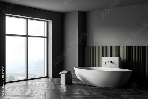 Grey and green bathroom with white bathtub  parquet floor and window