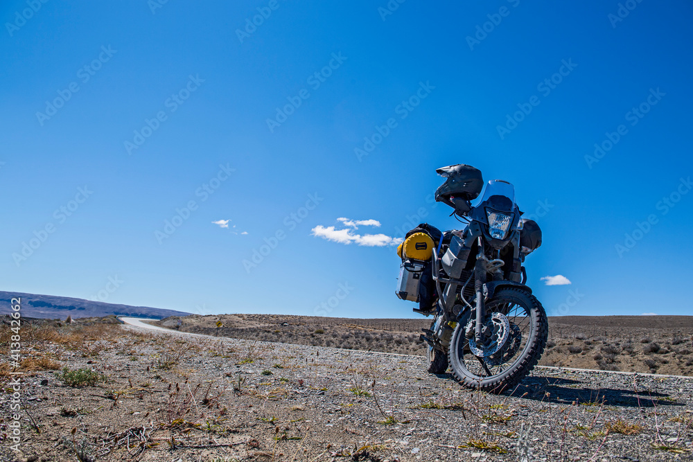 Adventure motorcycle parked at the side of highway in Argentina Adventure motorcycle parked at the side of highway in Argentina