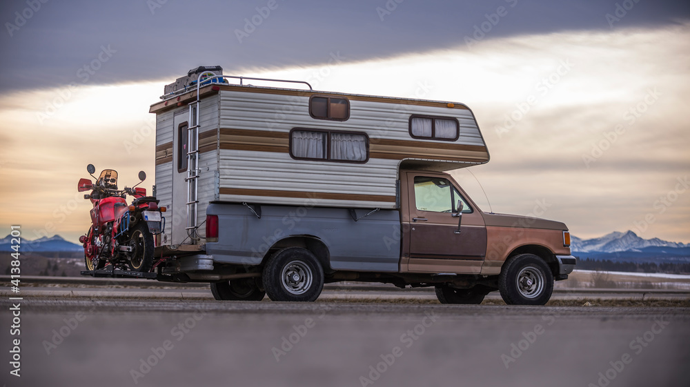 Camper Truck with Touring Motorcycle parked next to highway, sideview Camper Truck with Touring Motorcycle parked next to highway, sideview