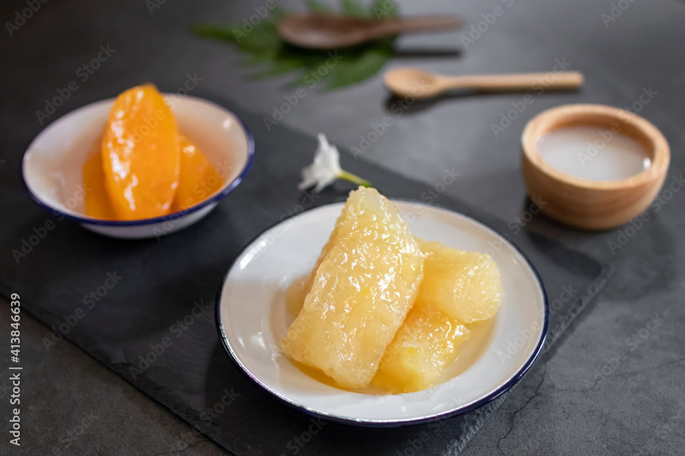 Cassava and Yam in syrup usually served coconut milk in vintage zinc coating dish on black stone background. Traditional desserts in Thailand. Cassava and Yam in syrup usually served coconut milk in vintage zinc coating dish on black stone background. Traditional desserts in Thailand.