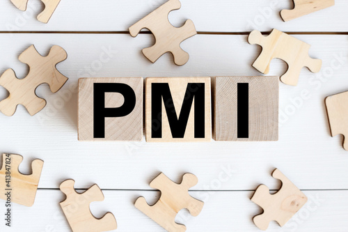 PMI. TEXT on wooden cubes on a white background. wood puzzles photo