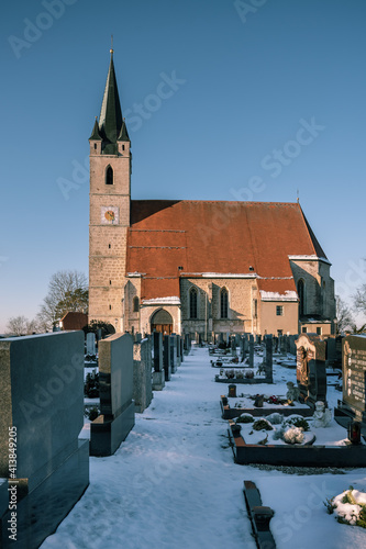 Kirch mit Friedhof im Winter vor blauem, Himmel, Tüßling,  St. Rupertus photo