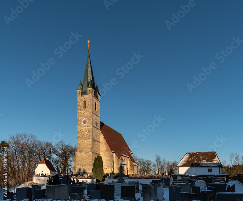 Kirch mit Friedhof im Winter vor blauem, Himmel, Tüßling,  St. Rupertus photo