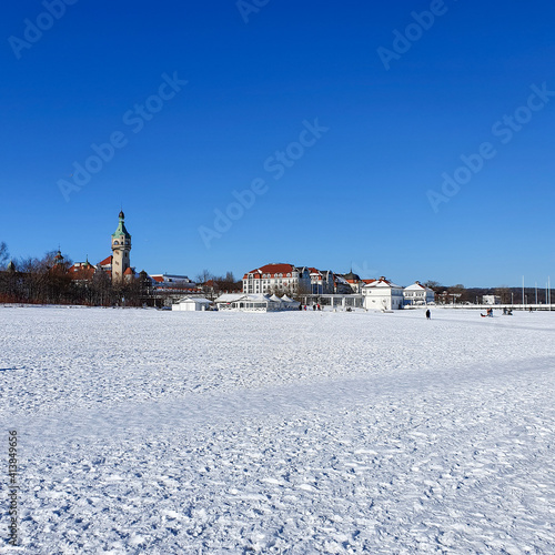 People are walking on a snow-covered beach in Sopot on a beautiful sunny day, Poland © abrada