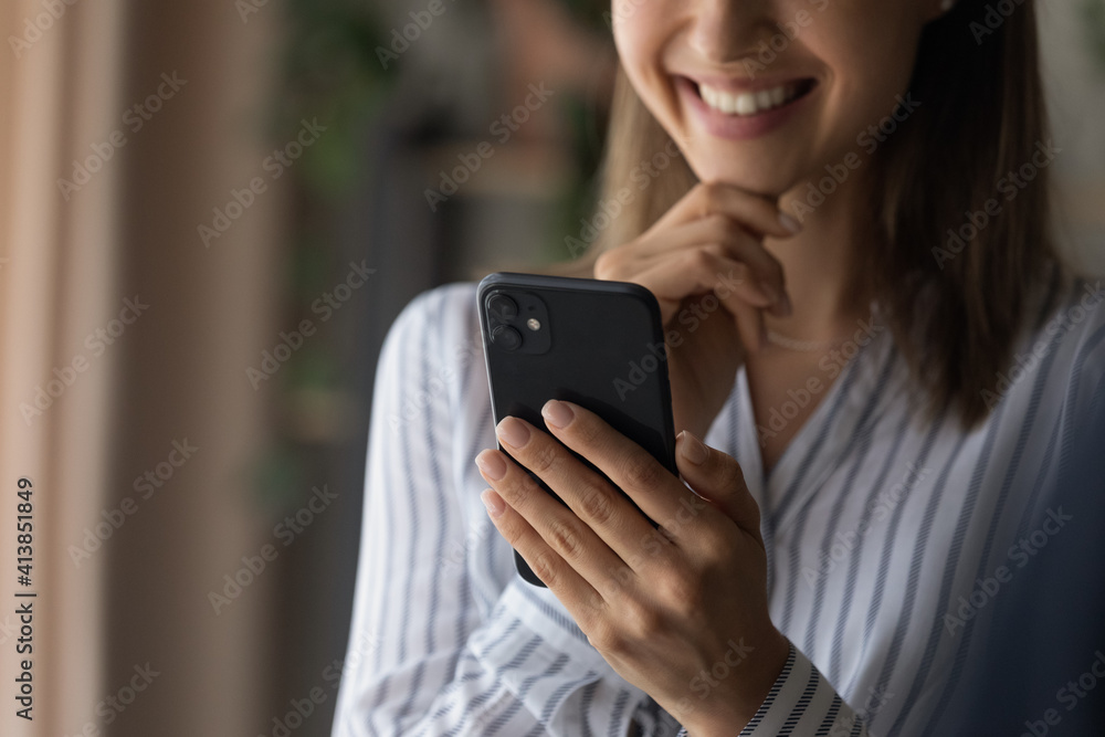 Close up cropped shot of smiling confident young woman enjoy using modern smartphone. Happy teen female read message from cell screen watch video in app search data online in internet social network