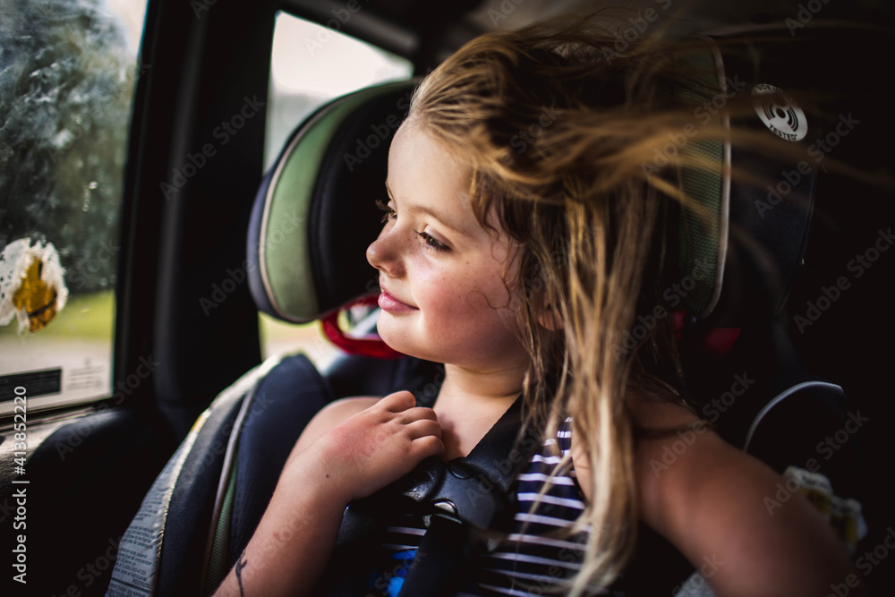 4-5 year old girl in backseat of jeep with wind blowing in her hair 4-5 year old girl in backseat of jeep with wind blowing in her hair