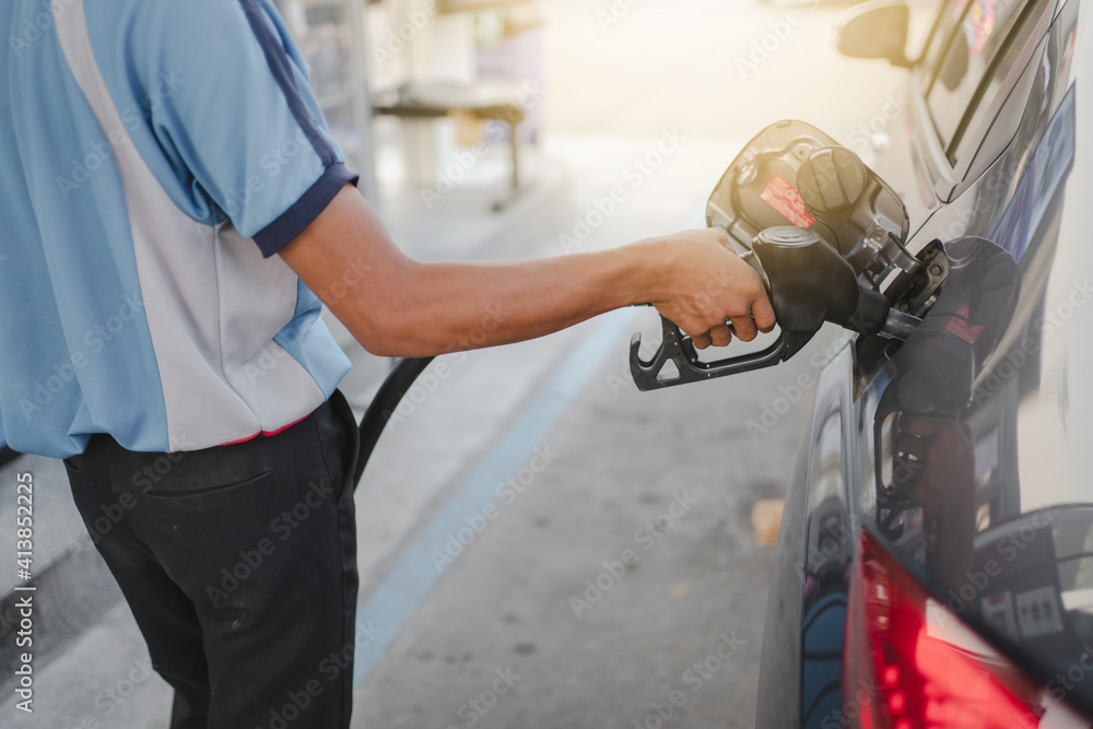 Hand of attendant holding refueling car and pumping at a gas petrol Station Hand of attendant holding refueling car and pumping at a gas petrol Station