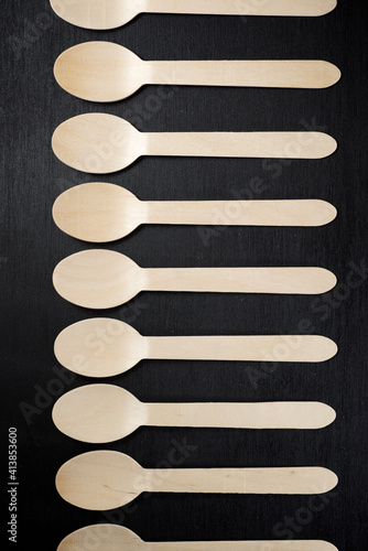 Disposable wooden cutlery on a black table. photo