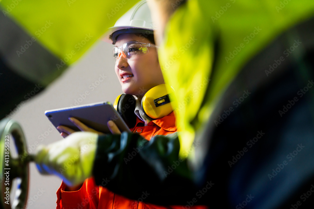 engineer cooperation Two asian maintenance engineers men and women inspect relay protection system with tablet device to control quality control process work a heavy industry manufacturing factory engineer cooperation Two asian maintenance engineers men and women inspect relay protection system with tablet device to control quality control process work a heavy industry manufacturing factory