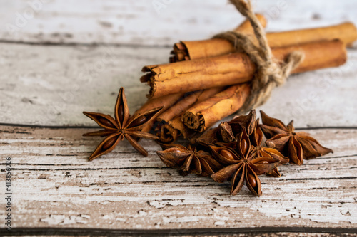 star anise and cinnamon sticks, cinnamon sticks and anise in on rustic wood background 