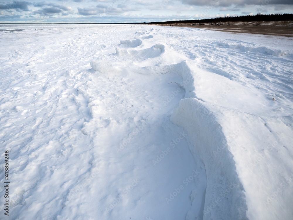 Frozen sea with snow and shoreline. Abstract snow formations.