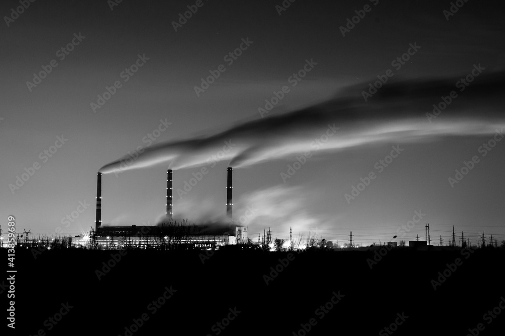 Steam from thermal power plant night view ahead of the river. Night photography with long exposure