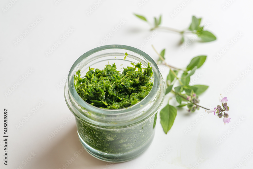 pesto sauce in a jar on a white background pesto sauce in a jar on a white background