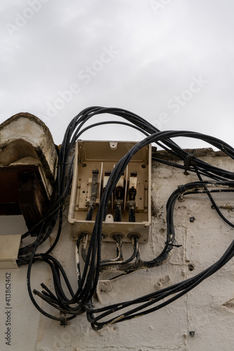 open electrical station with many cables leading in and out in an unsafe and haphazard manner © makasana photo