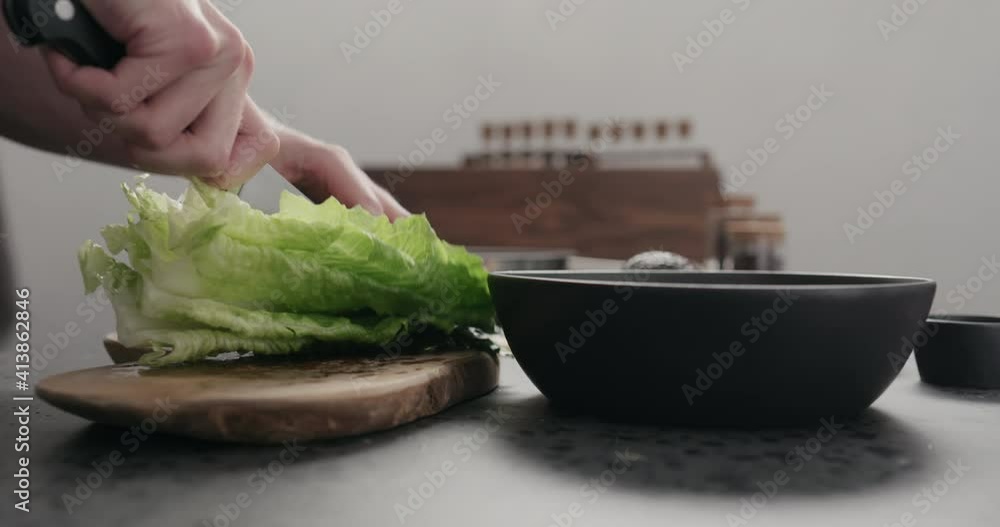 Slow motion man cut romaine for salad on kitchen countertop Slow motion man cut romaine for salad on kitchen countertop