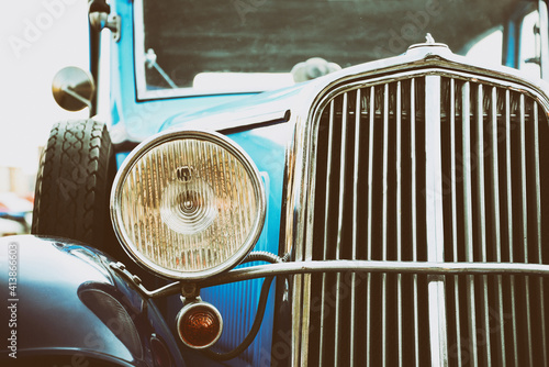 Close up of the front of an old classic car. Retro automotive. Detail of a front light. Vintage blue car. photo