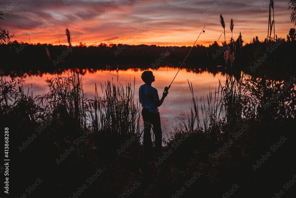 Sunset silohette of a boy fishing on a pond in North Alabama bobber Sunset silohette of a boy fishing on a pond in North Alabama bobber