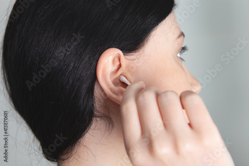 girl cleans her ears with a stick