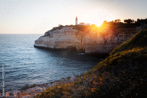 Farol de Alfanzia Lighthouse at sunset, Sagres, Algarve, Portugal photo