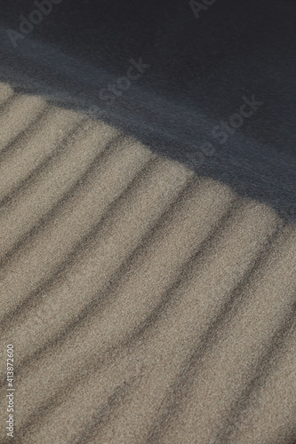 close up of shadows and lines in taupe colored sand photo