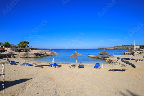 Fototapeta Naklejka Na Ścianę i Meble -  Beach with sun loungers and sun umbrellas in Ksamil resort