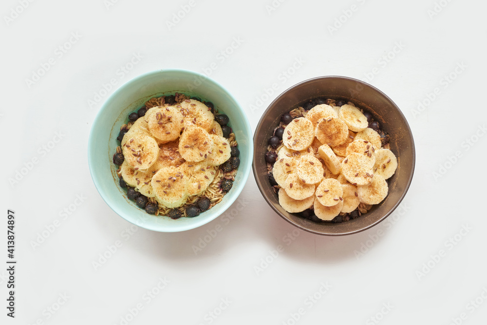 Healthy breakfast. Top view. Oatmeal with banana and flax seeds at bowl. Berry in plate. Organic meal recipe. Vegan cook. Minimalism granola. Hot porrigde with fruit Healthy breakfast. Top view. Oatmeal with banana and flax seeds at bowl. Berry in plate. Organic meal recipe. Vegan cook. Minimalism granola. Hot porrigde with fruit