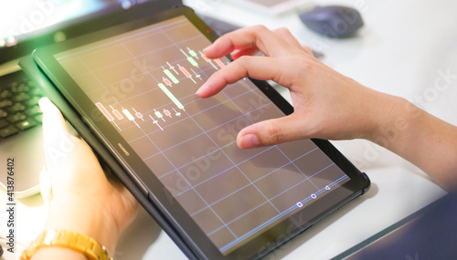 Businessman checking stock market dataมStock Market Application for Mobile, Analyzing Data Stock Market on Mobile Young Businessman with Smartphone and Stock Market Chart Background.