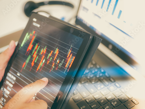 Businessman checking stock market dataมStock Market Application for Mobile, Analyzing Data Stock Market on Mobile Young Businessman with Smartphone and Stock Market Chart Background.