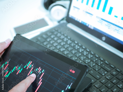 Businessman checking stock market dataมStock Market Application for Mobile, Analyzing Data Stock Market on Mobile Young Businessman with Smartphone and Stock Market Chart Background.